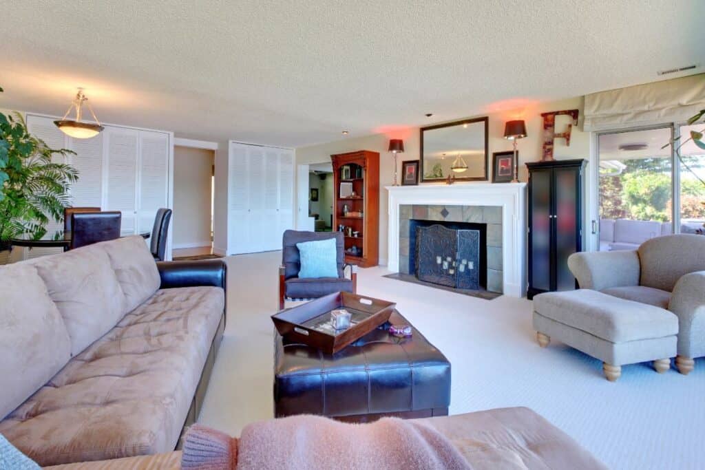 Cosy home updates – carpeted living room with fireplace, layered lighting and comfy seating
