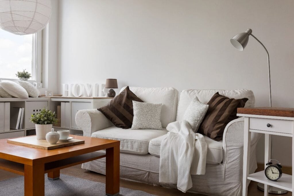 Home updates to transform your space — cosy living room with white sofa, layered cushions and clean, simple styling
