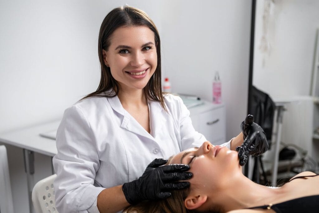 Aesthetic practitioner assessing a client’s brows before laser microblading removal in a clinic setting.