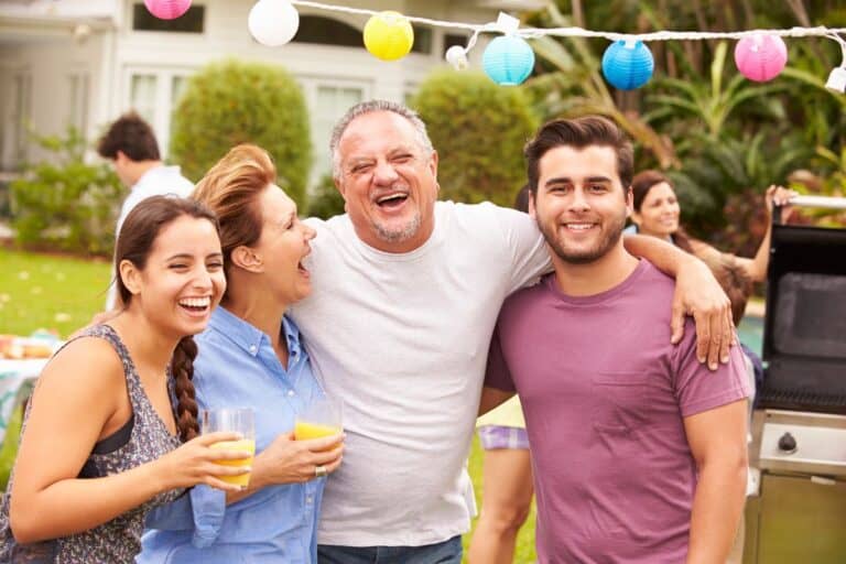 Celebration culture at home: family laughing together at a garden gathering.