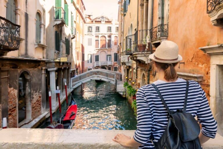 Plan your next European break: traveller overlooking a canal in Venice, Italy