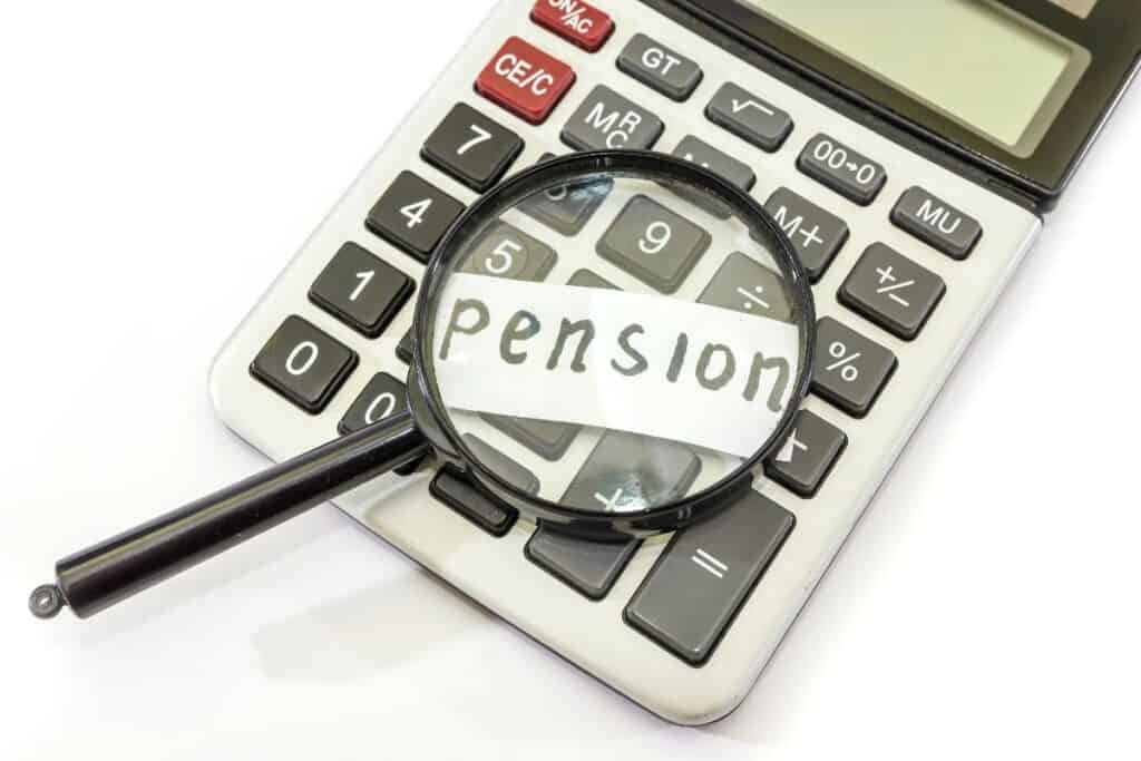 Magnifying glass over the word “pension” on a calculator, highlighting pension value in divorce.