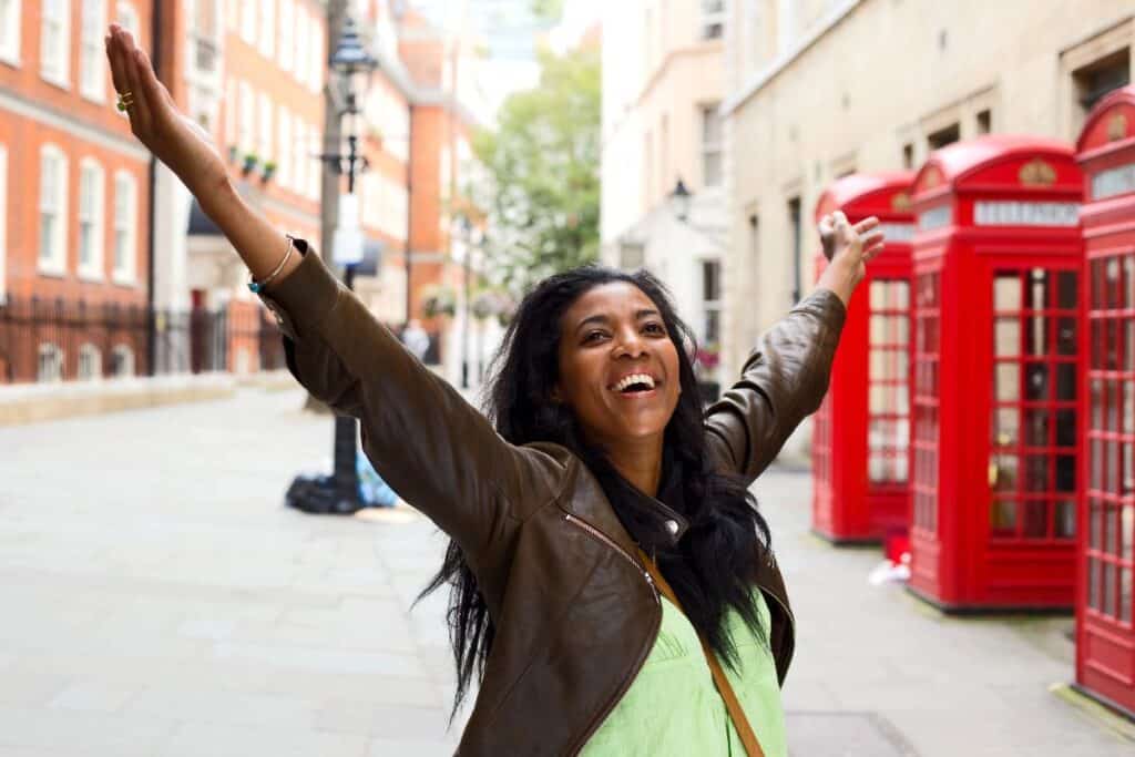 Woman in light jacket near red phone boxes – what to wear in British summer weather
