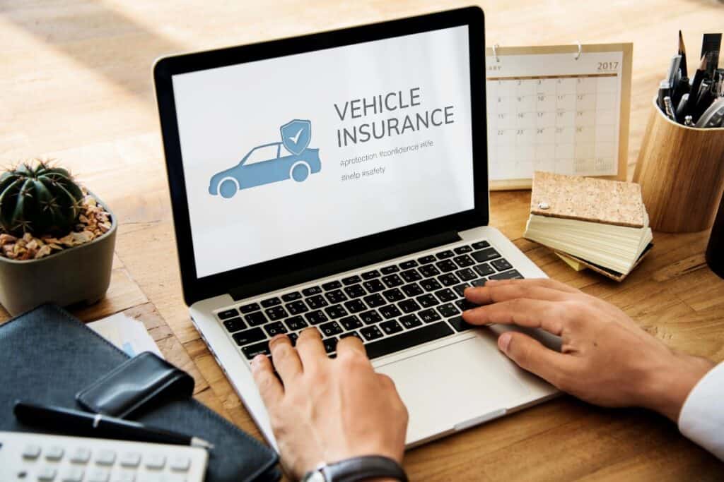 Laptop screen showing “vehicle insurance” as a person researches multi-vehicle cover for a small business.