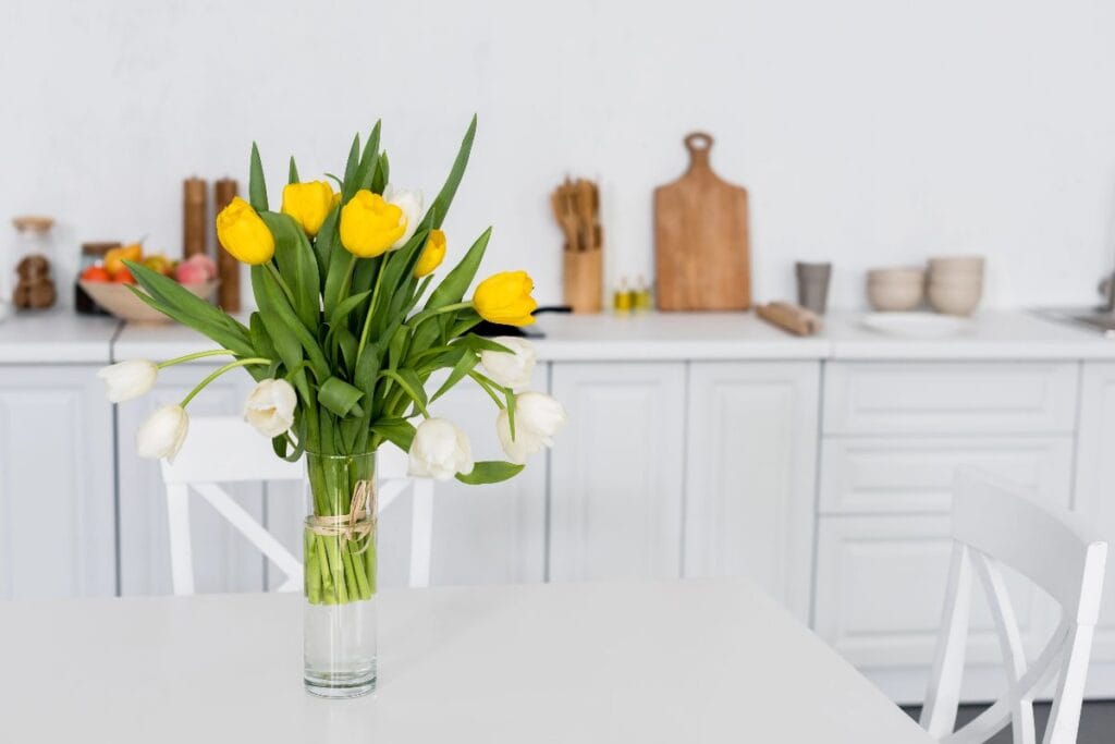Spring kitchen decor with yellow and white tulips on a dining table