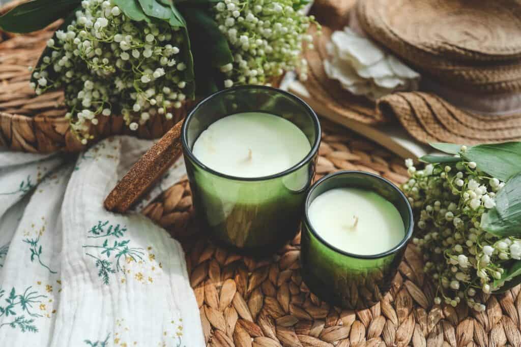 Spring home scents with green candles, flowers and natural woven decor