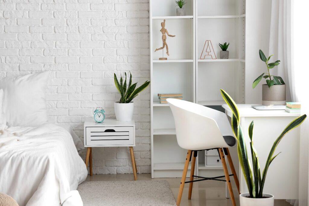 Multi-use bedroom with white desk, shelving and bed in a bright, organised layout