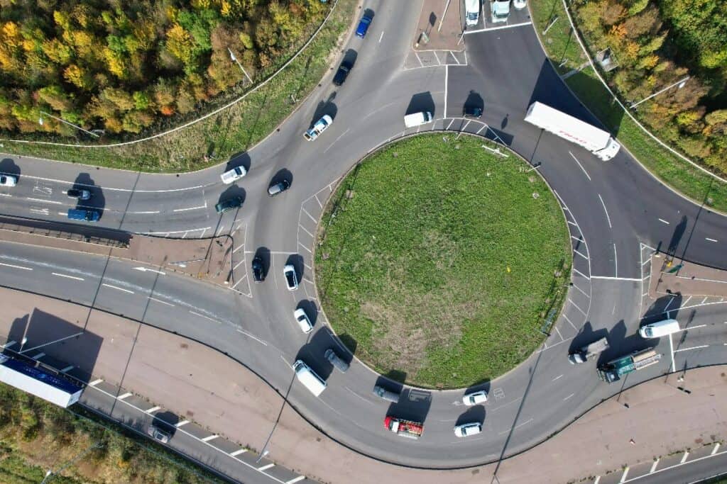 Aerial view of a busy roundabout with cars, driving in the UK for the first time tip on roundabouts.
