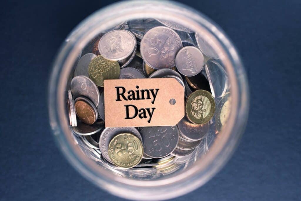 Jar of coins labelled rainy day fund for emergency savings