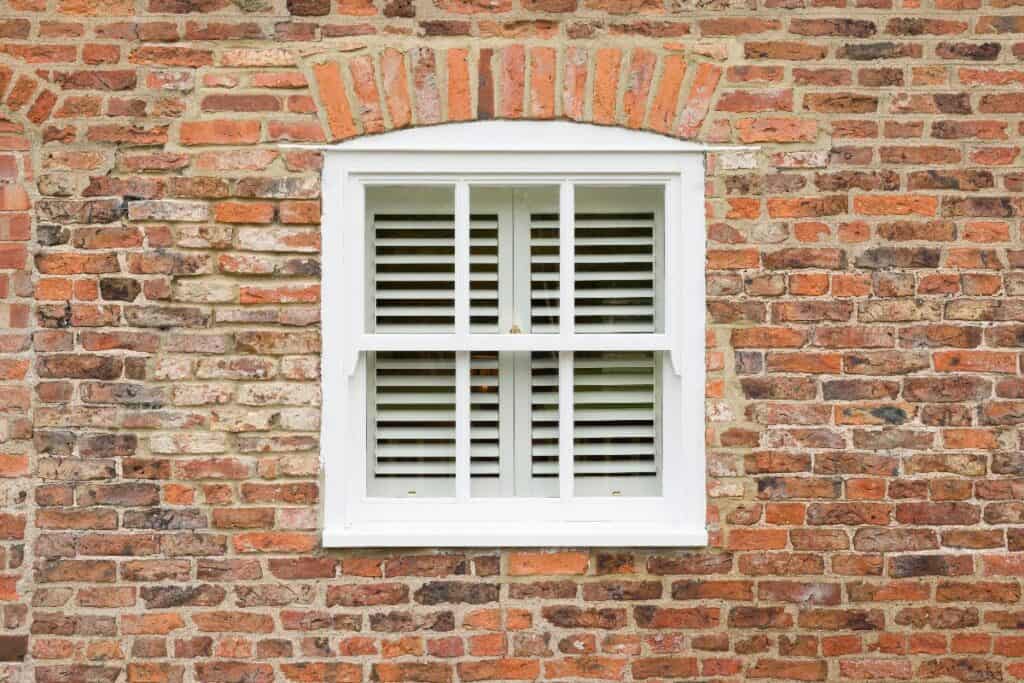 White sash windows in an old brick property.