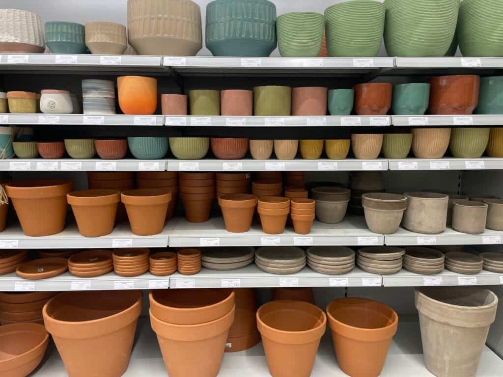 Shelves of outdoor plant pots in different colours, sizes and finishes for a garden project.
