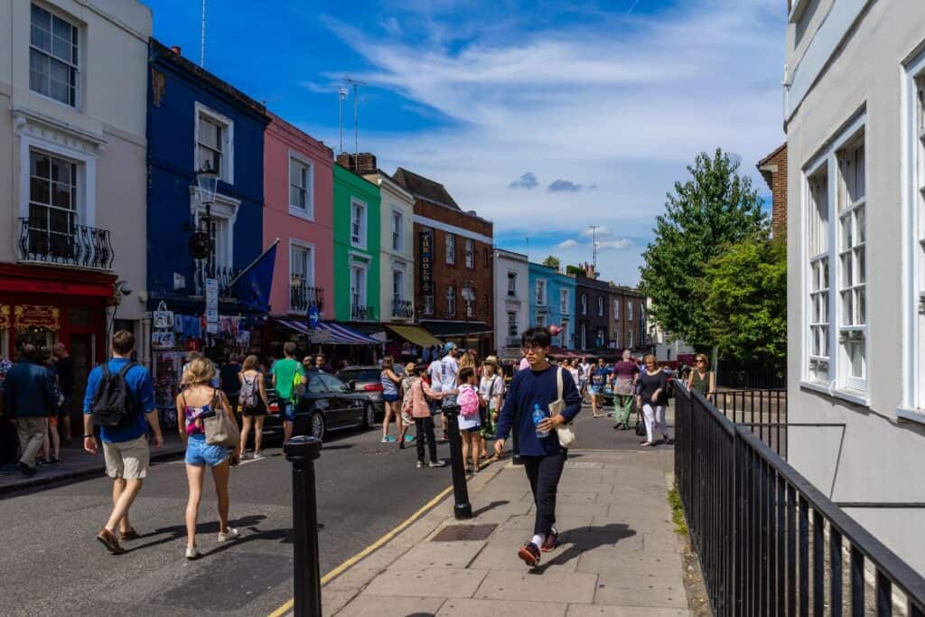 Portobello Market in Notting Hill with colourful shopfronts, used in a relocating to London guide about neighbourhoods and London life
