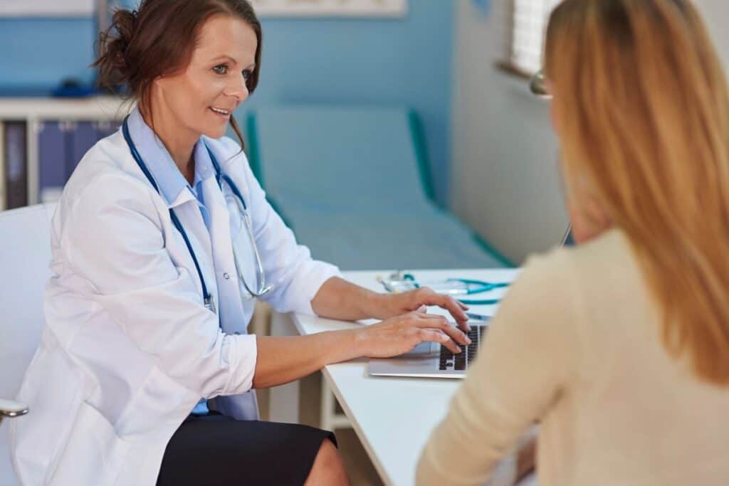 Doctor speaking with a patient during a medical appointment about UTI symptoms.