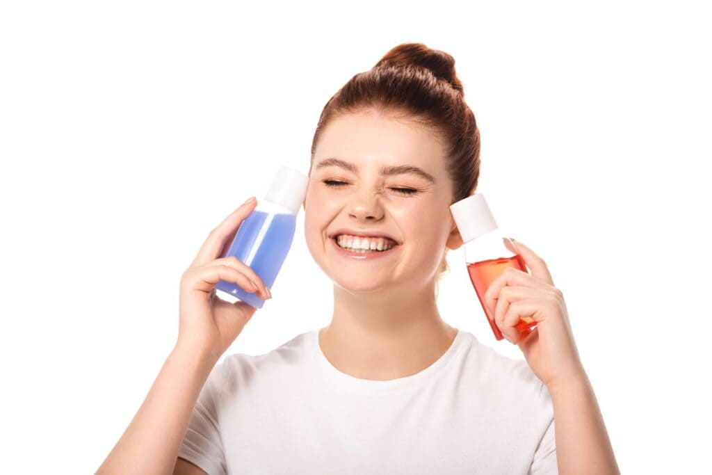 Smiling teen girl holding skincare products for a simple sensitive skin routine.