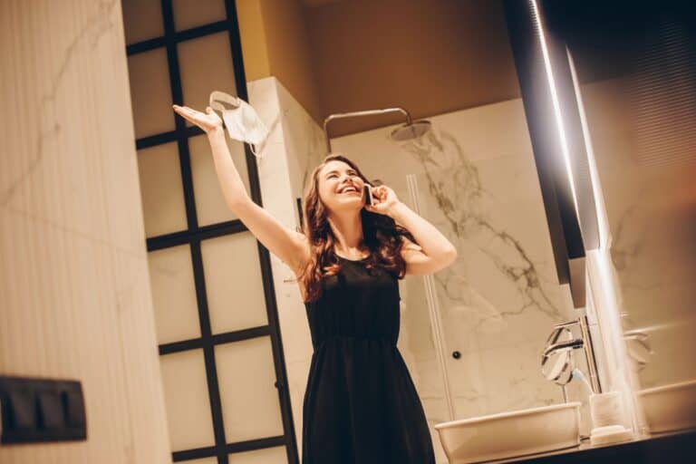 Woman wearing a black dress getting ready for an evening out in a guide on how to style a black dress.
