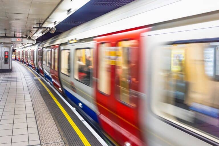 London Underground train arriving at a platform for a relocating to London guide about transport, commuting and settling into city life