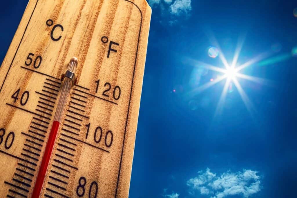 Thermometer showing high temperatures in bright summer sun during a heatwave.
