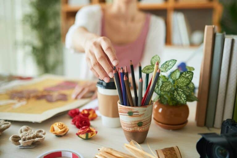 Person choosing coloured pencils for a creative hobby at home.