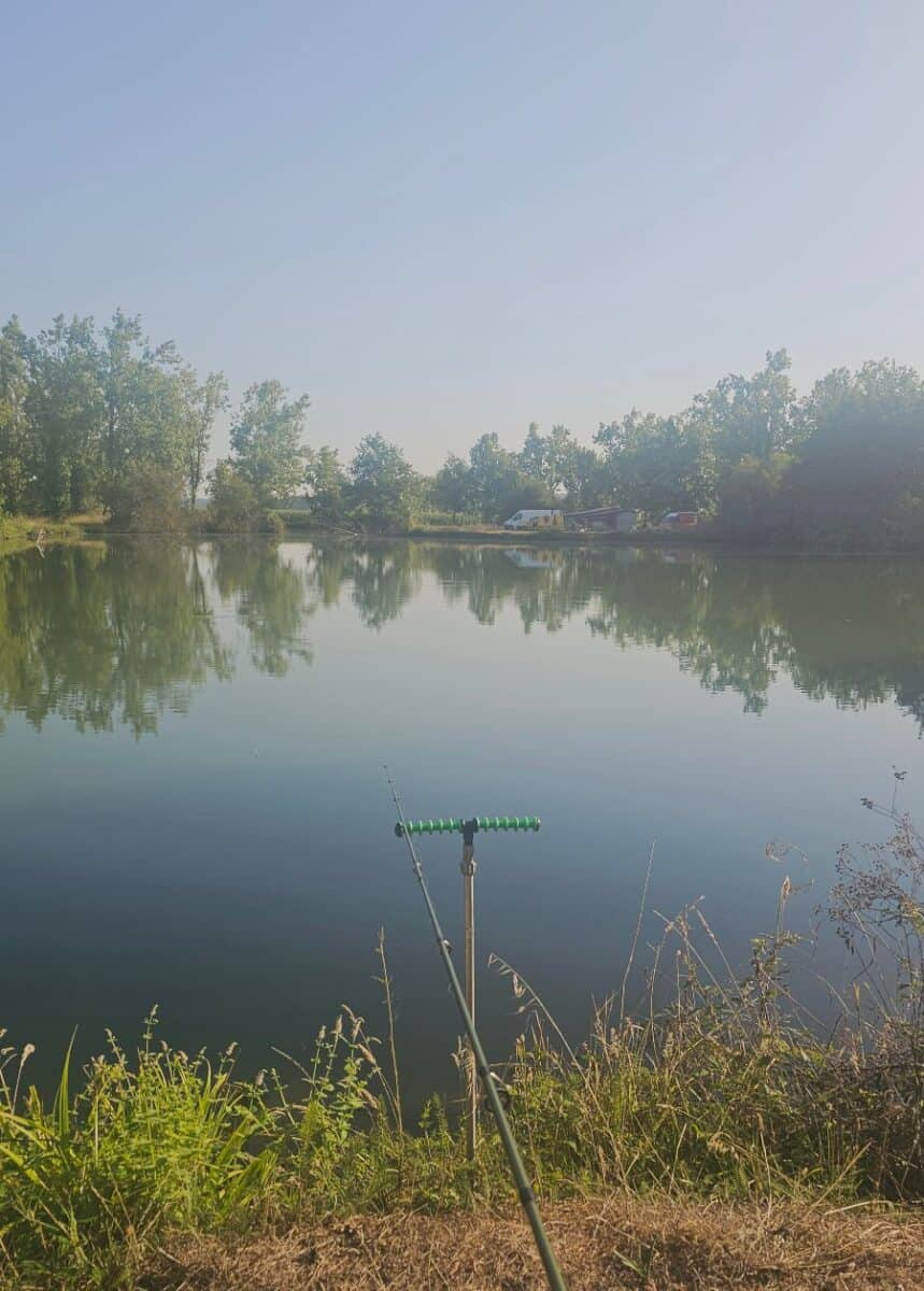 Fishing rod set up beside a peaceful rural lake in France