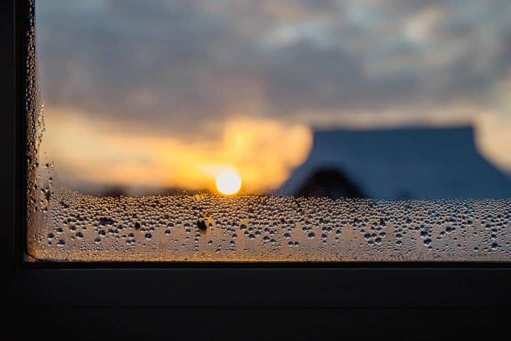 Condensation droplets on a window with sunrise outside