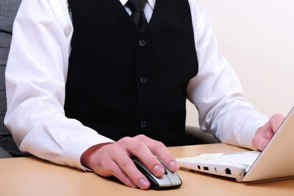 Hotel staff member using a laptop to manage guest booking information
