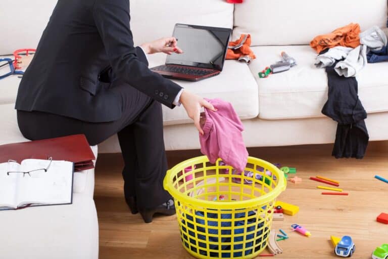 Busy woman juggling work, laundry and family life at home.
