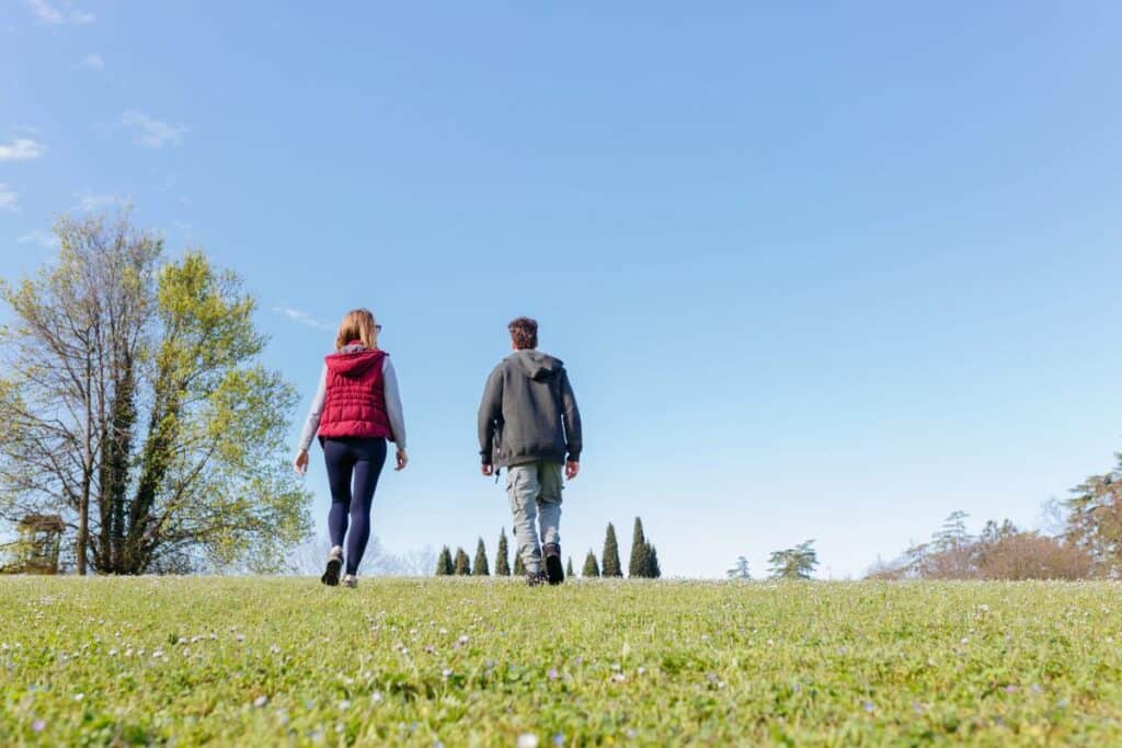 Two people walking outdoors together as part of a healthy recovery routine