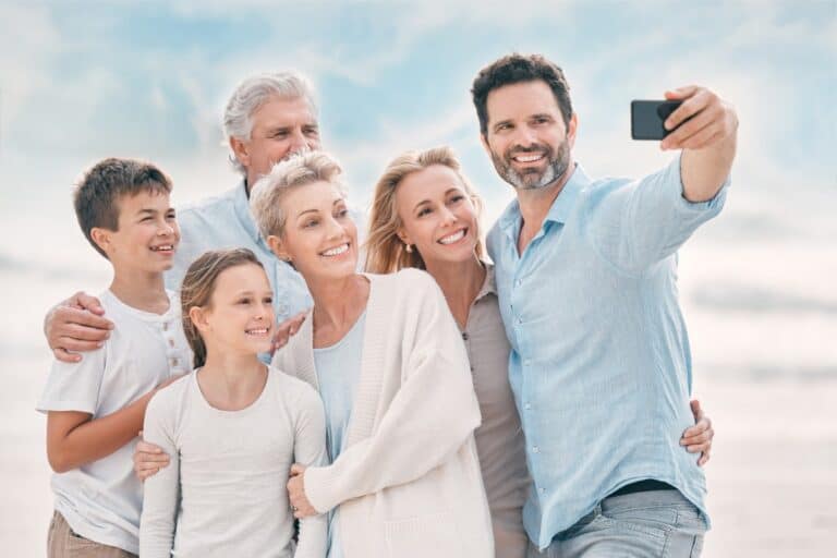 Multigenerational family taking a selfie together on the beach