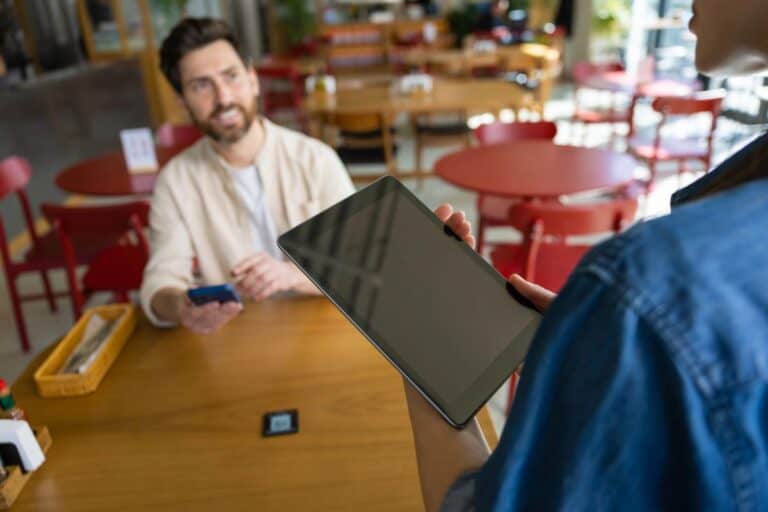 Restaurant server taking a customer’s order using a tablet