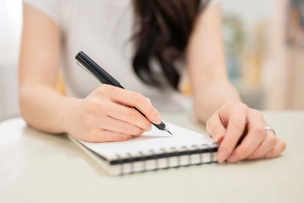 Woman writing a short to-do list to make a task easier to start.