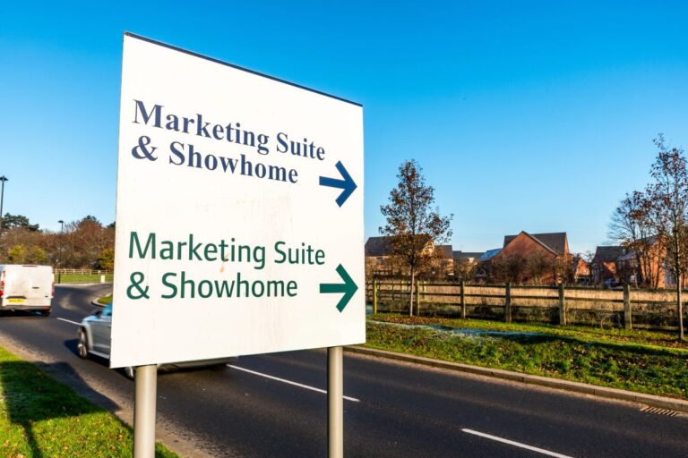 Sign directing visitors to a new-build marketing suite and show home.